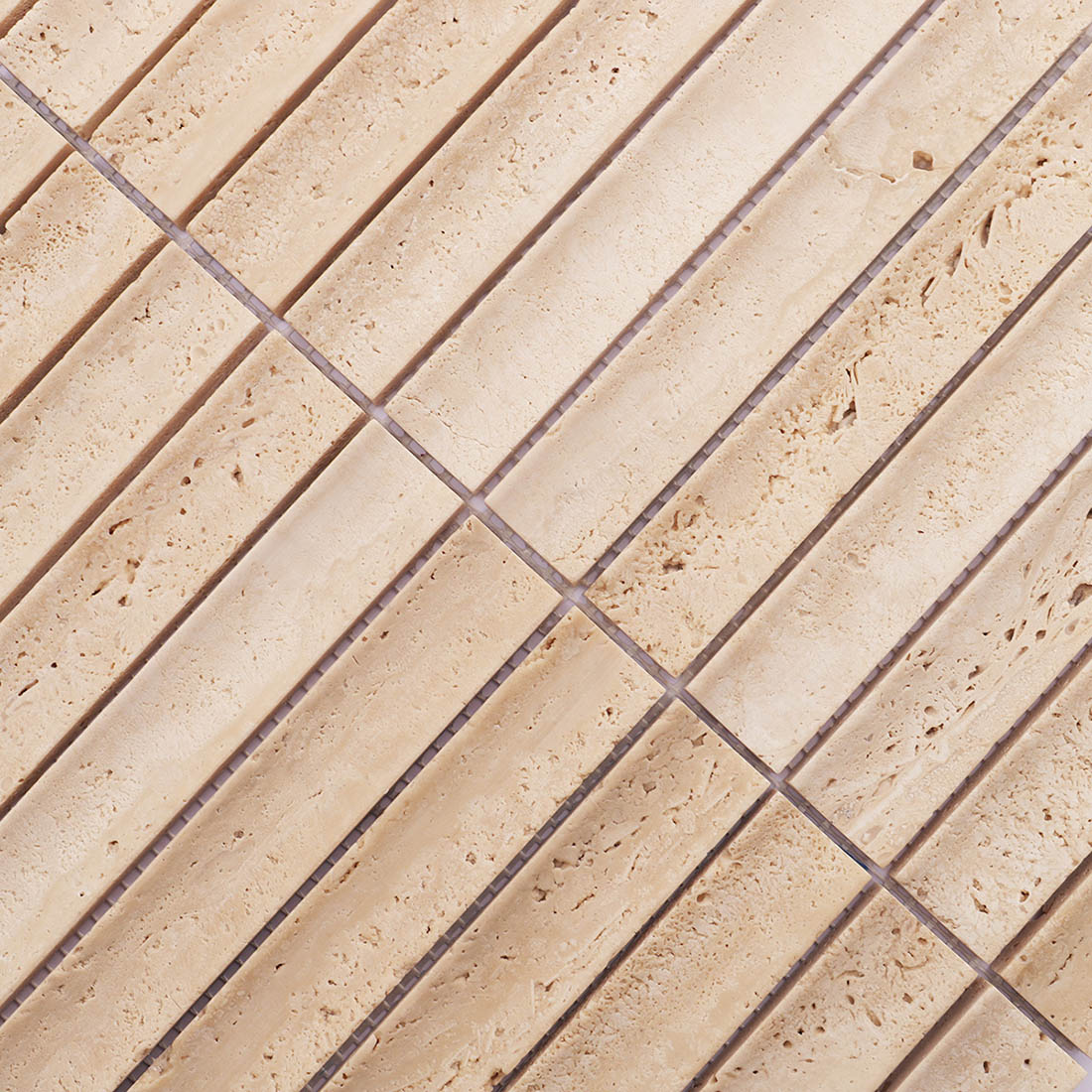 Close-up of beige grooved travertine mosaic tiles with natural stone variation