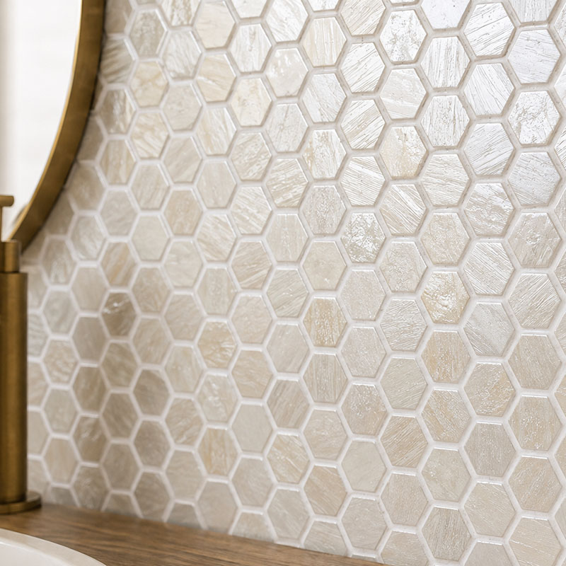 Close-up of beige hexagon glass mosaic tiles with a textured glossy finish