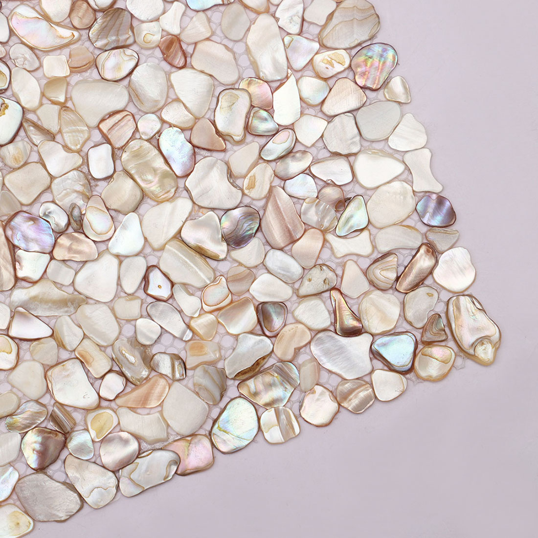 Close up of beige iridescent mother of pearl pebble mosaic tile corner detail