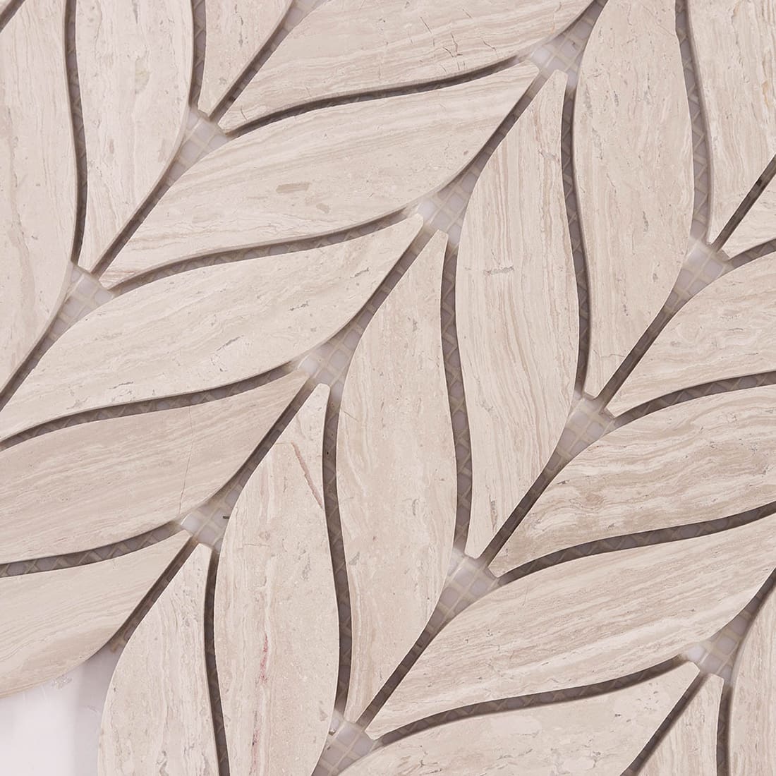 Close up of beige marble leaf mosaic surface showing natural stone veining.