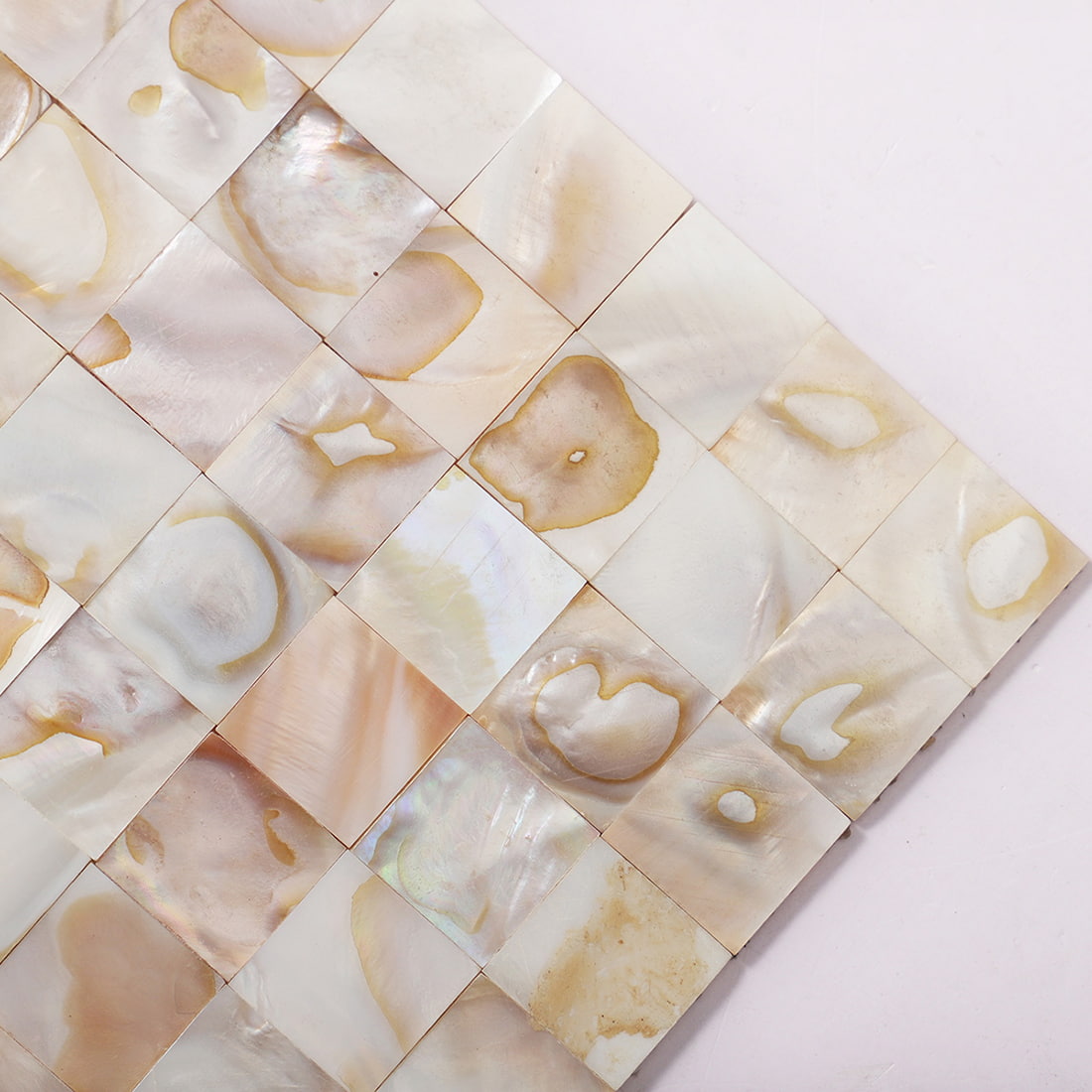 Close up corner of beige natural shell square mosaic tile sheet