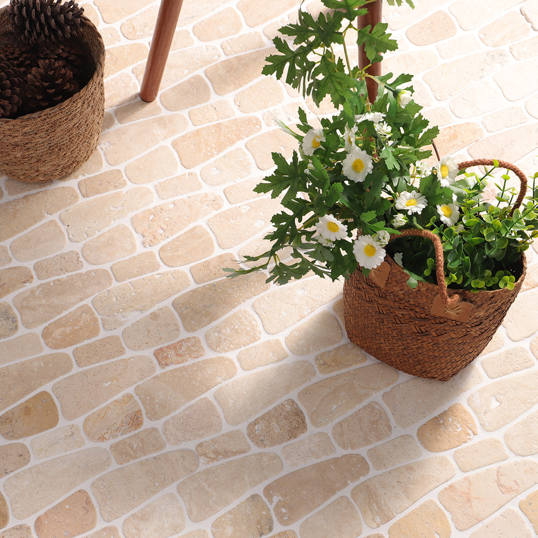 Beige pebble stone mosaic floor with white grout in a bright patio setting