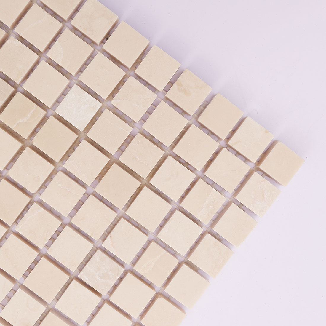 Corner detail of beige square marble mosaic tile with soft natural variation