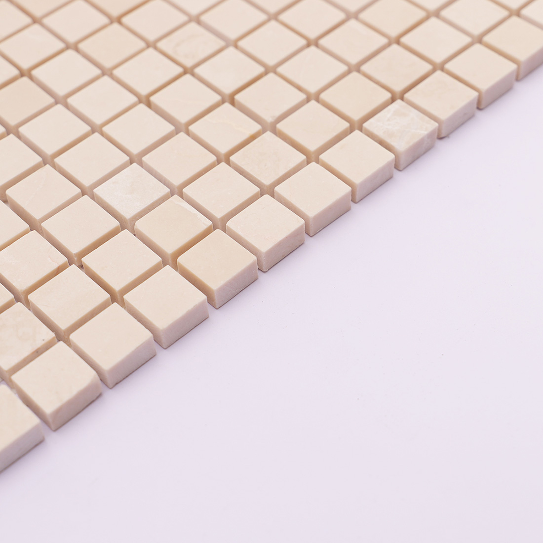 Side edge of beige square marble mosaic tile with a natural stone finish