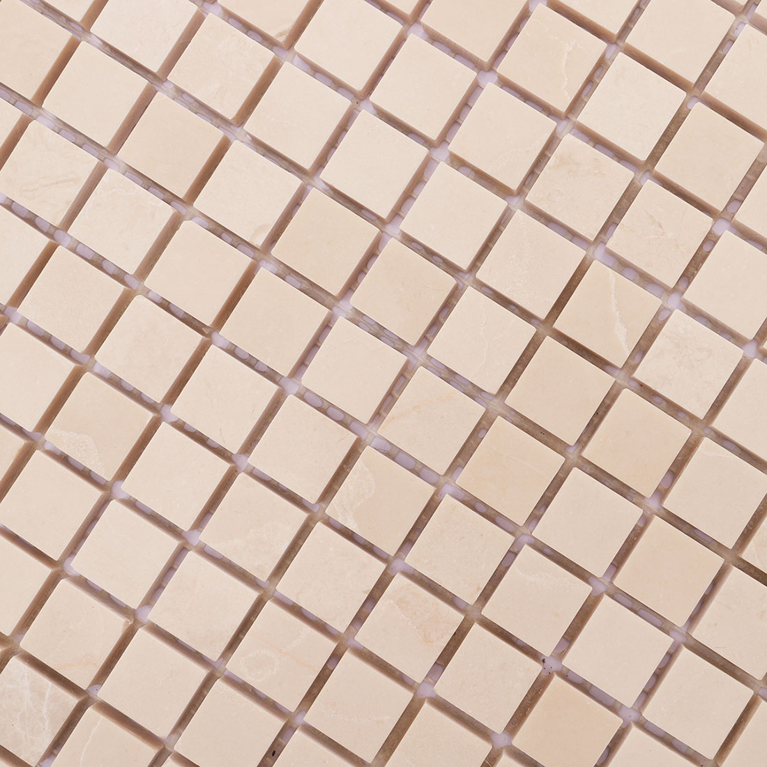 Close-up of beige square marble mosaic tiles with delicate natural veining