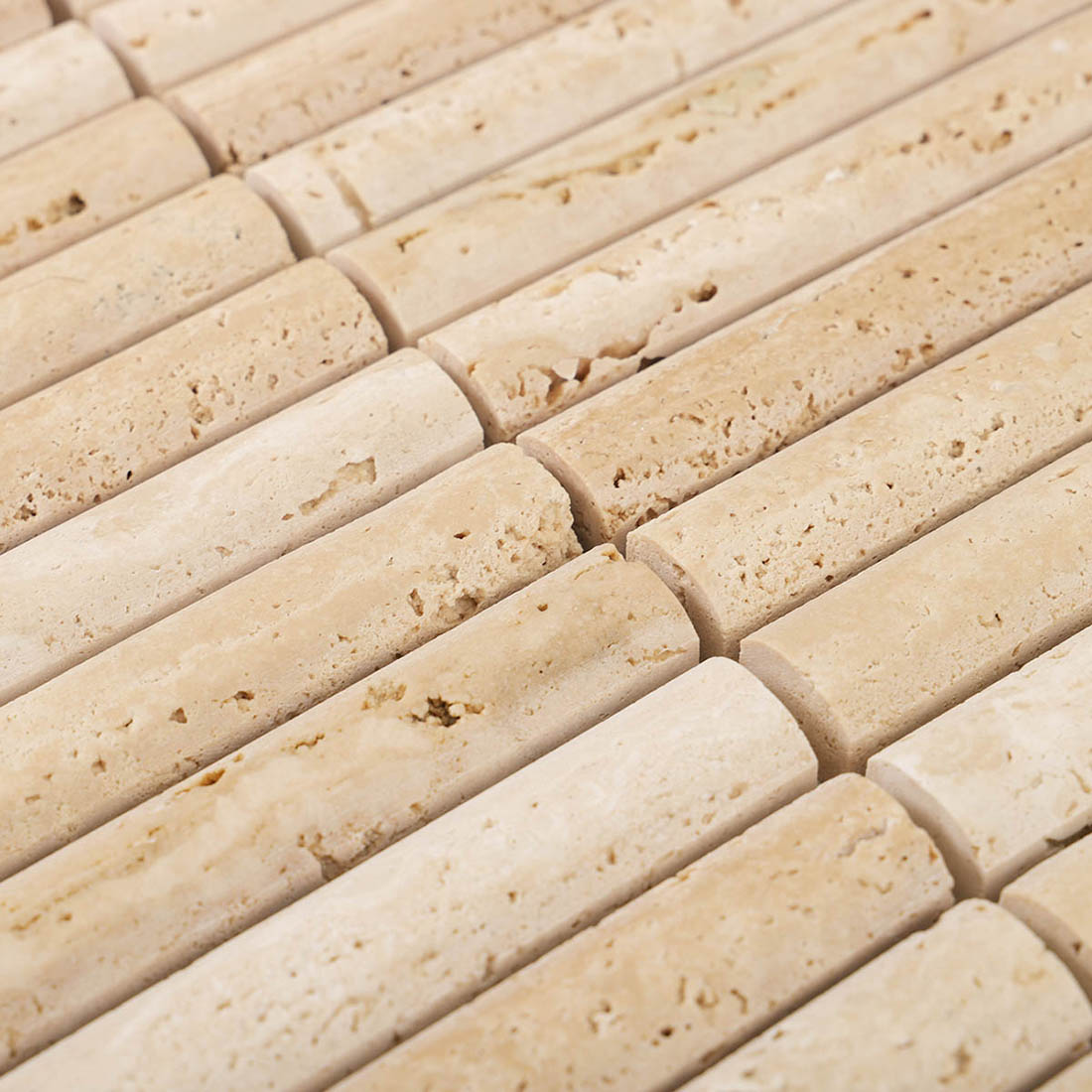Beige travertine mosaic strips with curved concave ends and porous texture