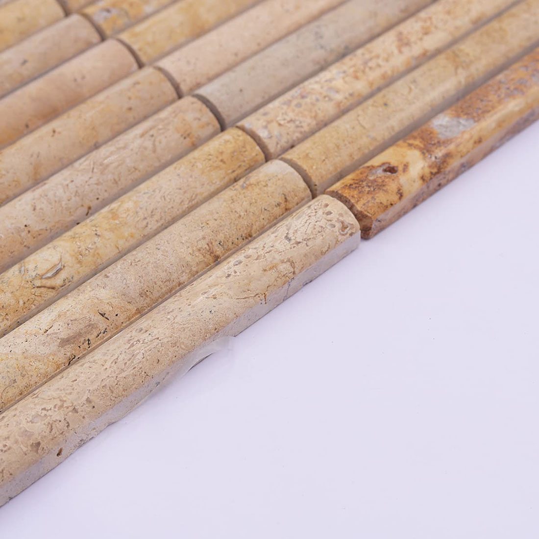 Angled view of beige travertine strips showing rounded tops and tile thickness