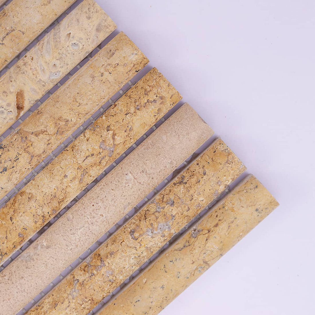 Close-up of beige travertine strips showing natural pores and warm variation