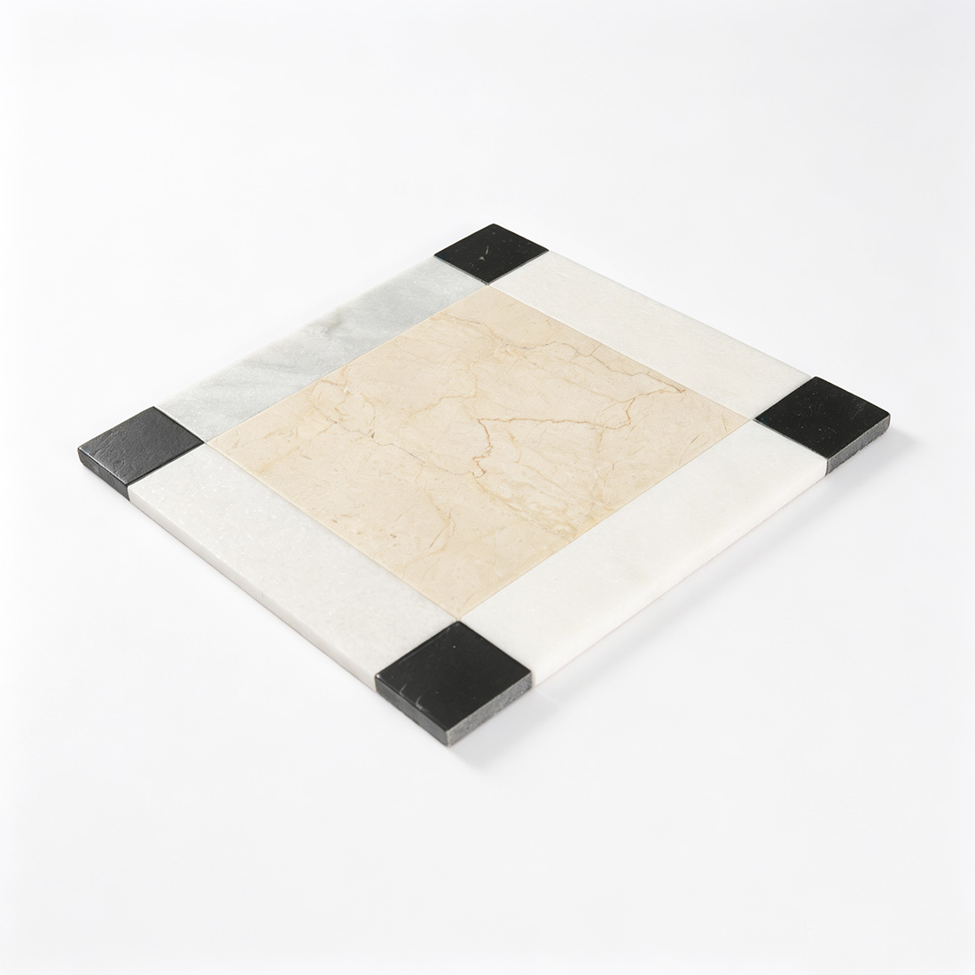 Angled view of beige marble tile with white border and black corner accents