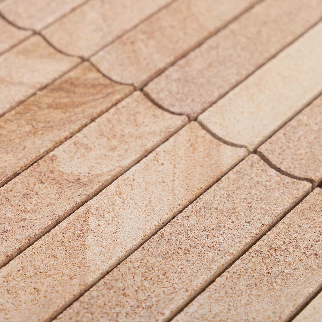 Closeup of beige stone mosaic surface showing grout lines and texture