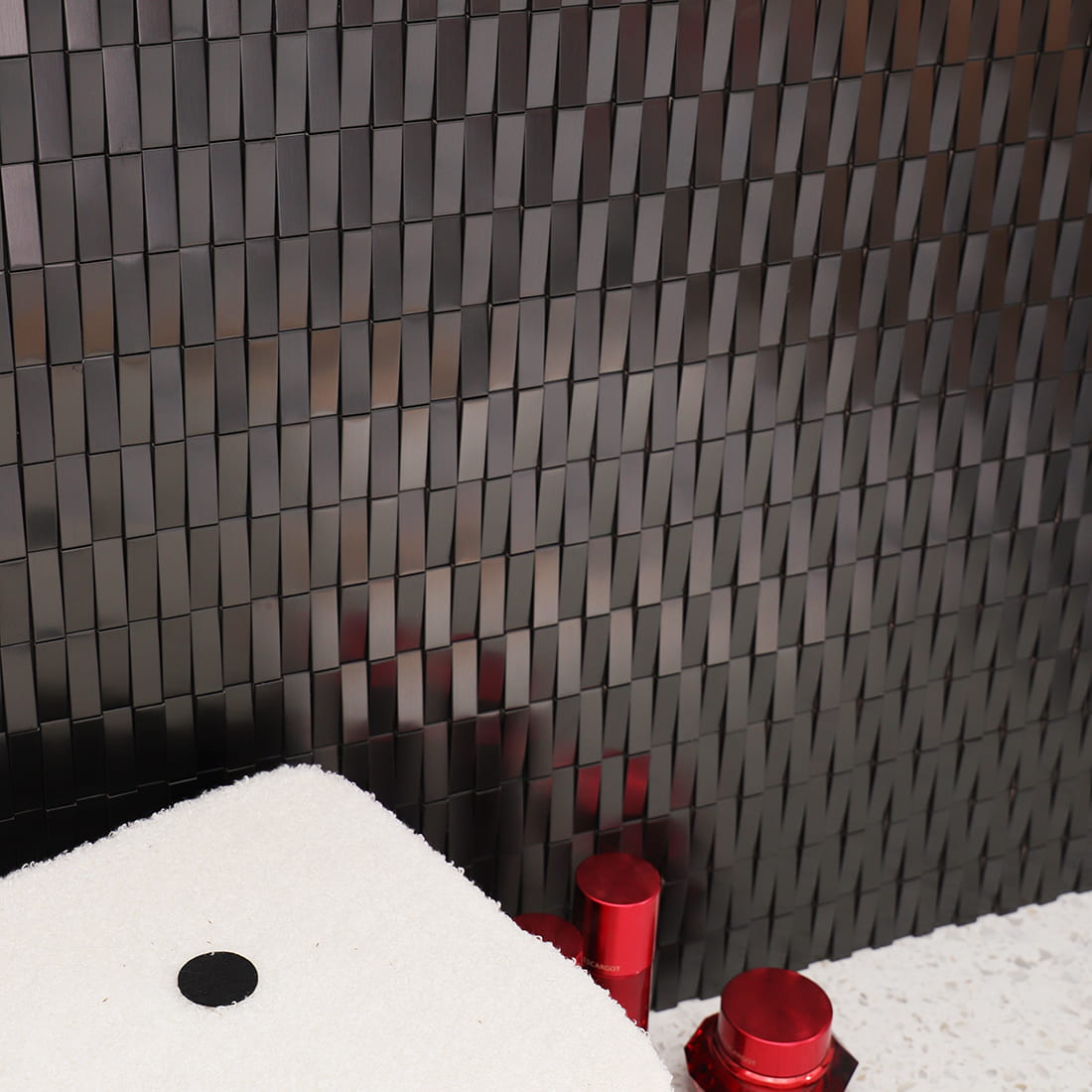 Side view showing the slanted 3D effect of black rectangular stainless steel tiles.