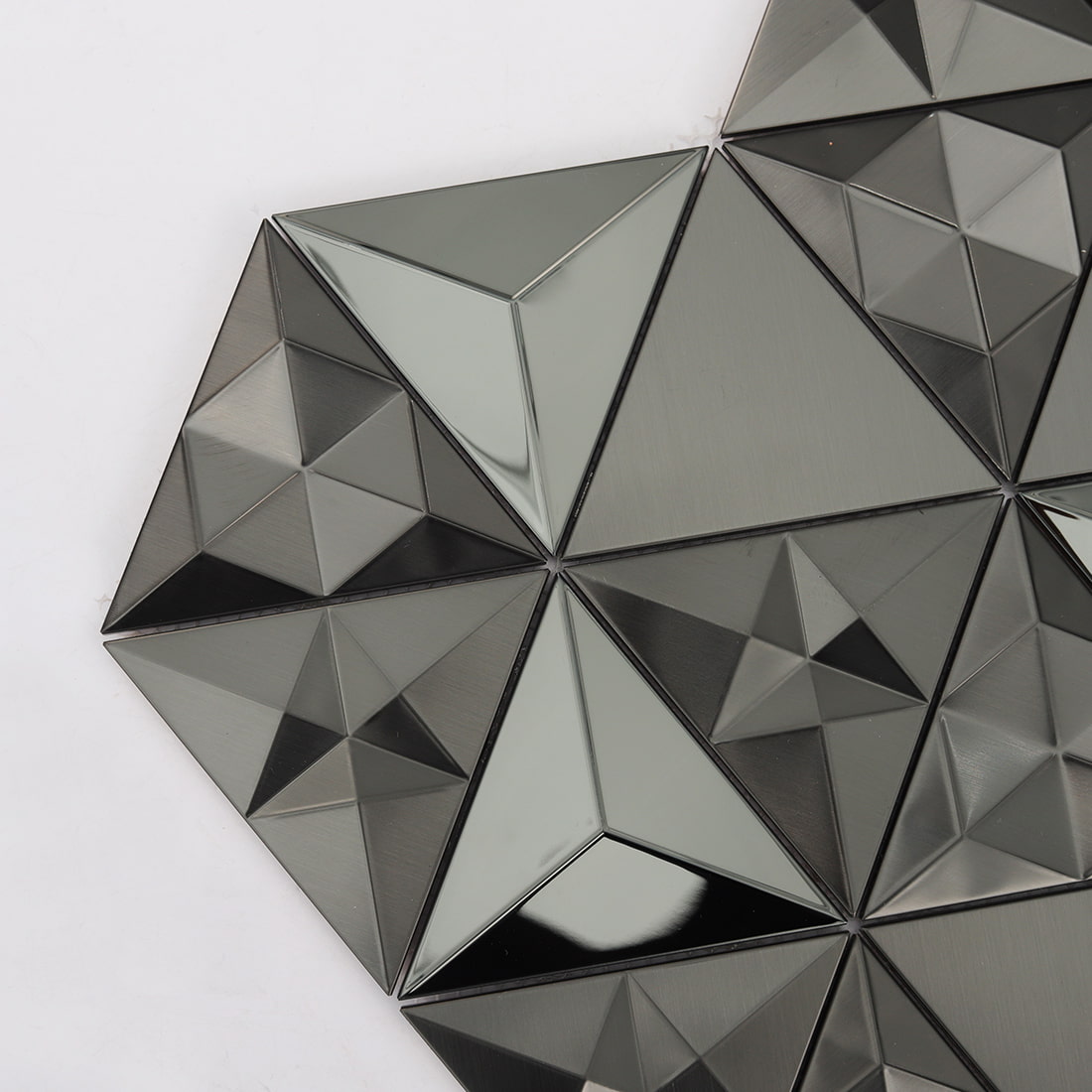 Corner detail of black 3D triangle stainless steel tile with mixed finishes