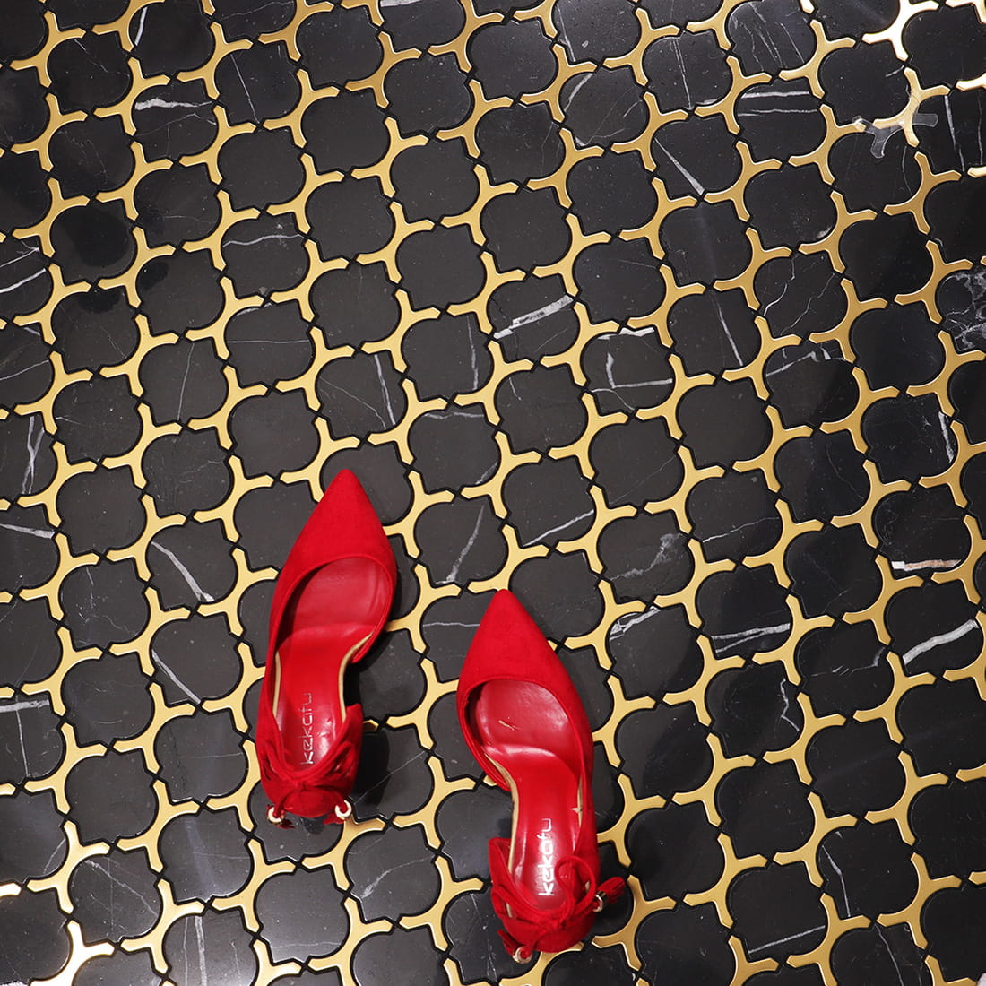 Black and gold marble mosaic floor tile scene with red high heels