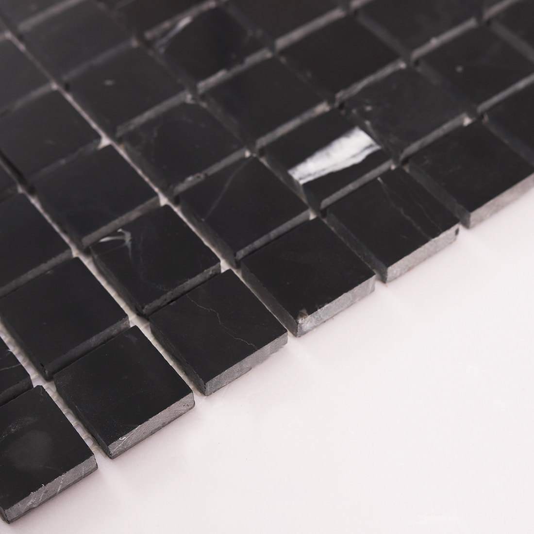 Surface texture of black marble mosaic tile with white veins