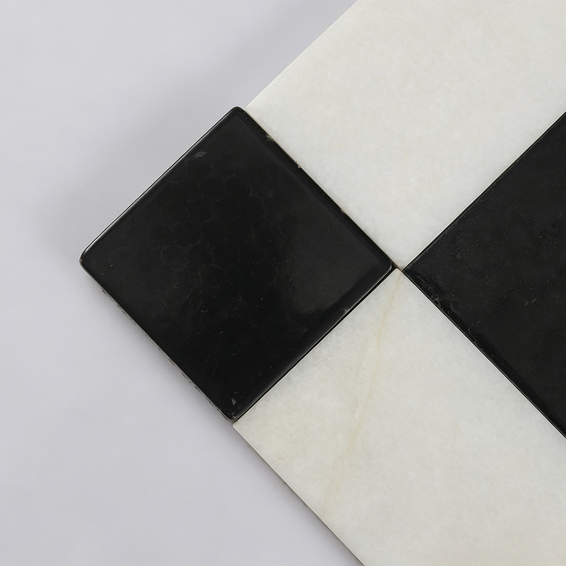 Close-up of black marble corner accent and white marble border tile