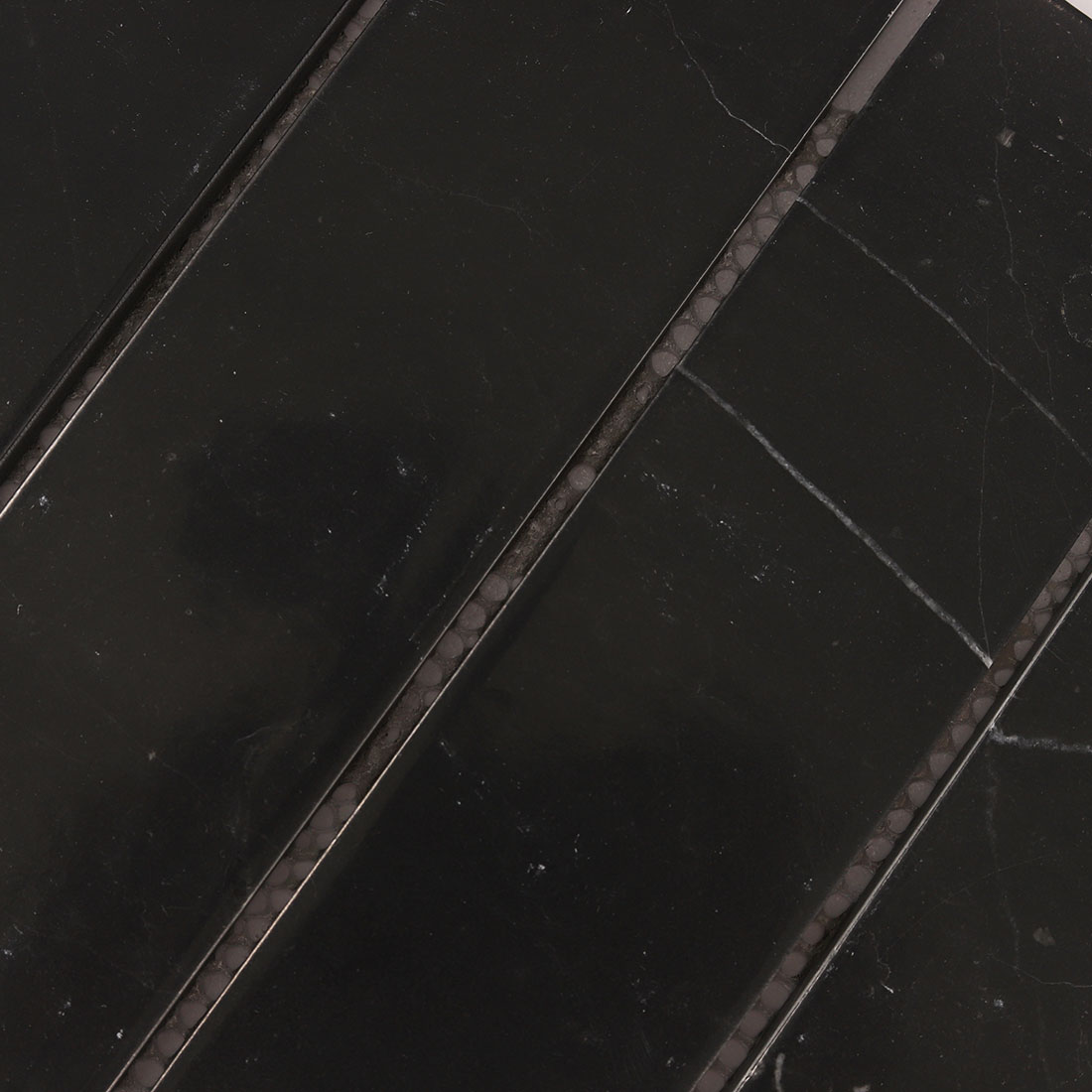 Close-up of black marble mosaic strips with fine white veining