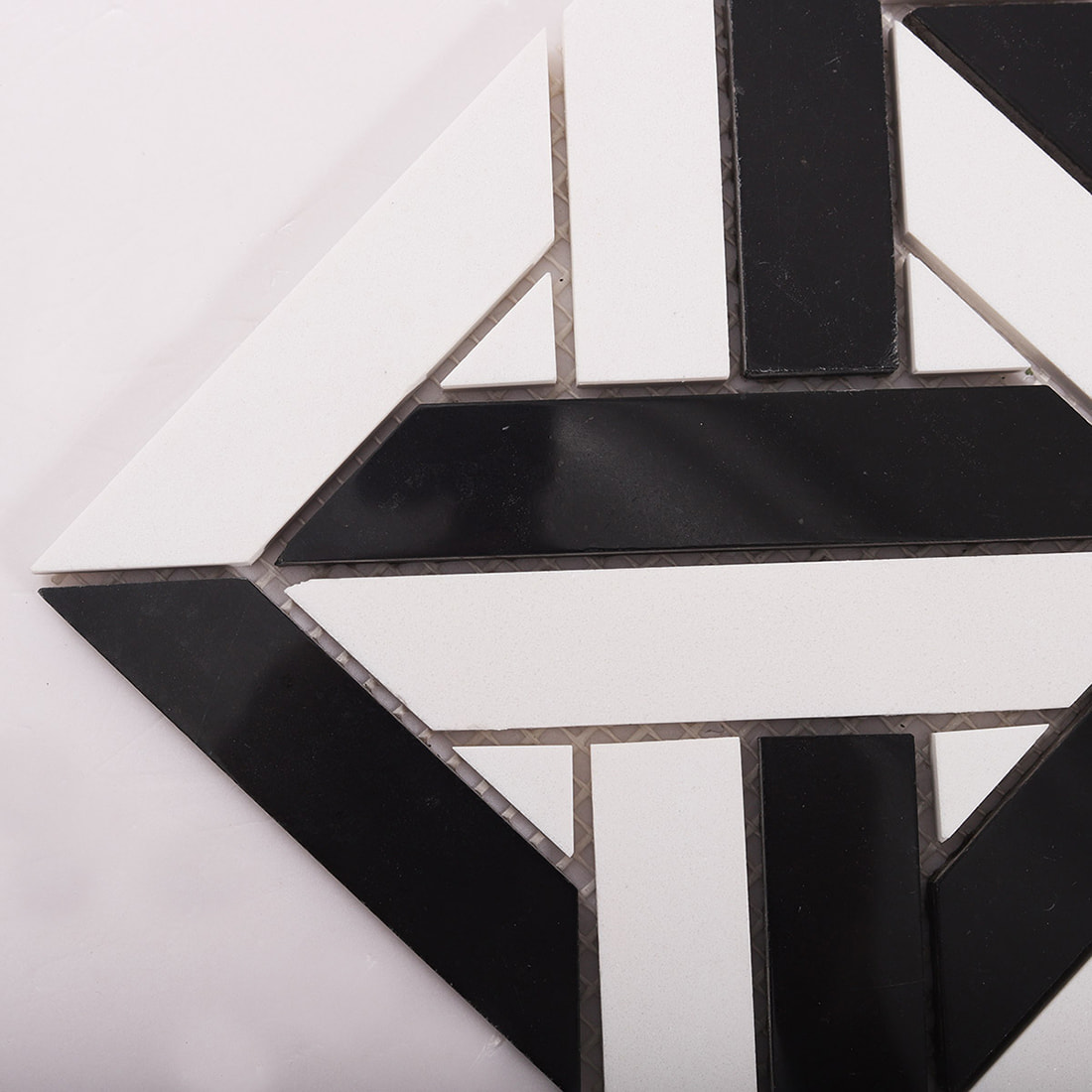 Corner close up of black and white geometric mosaic showing crisp cuts and joints