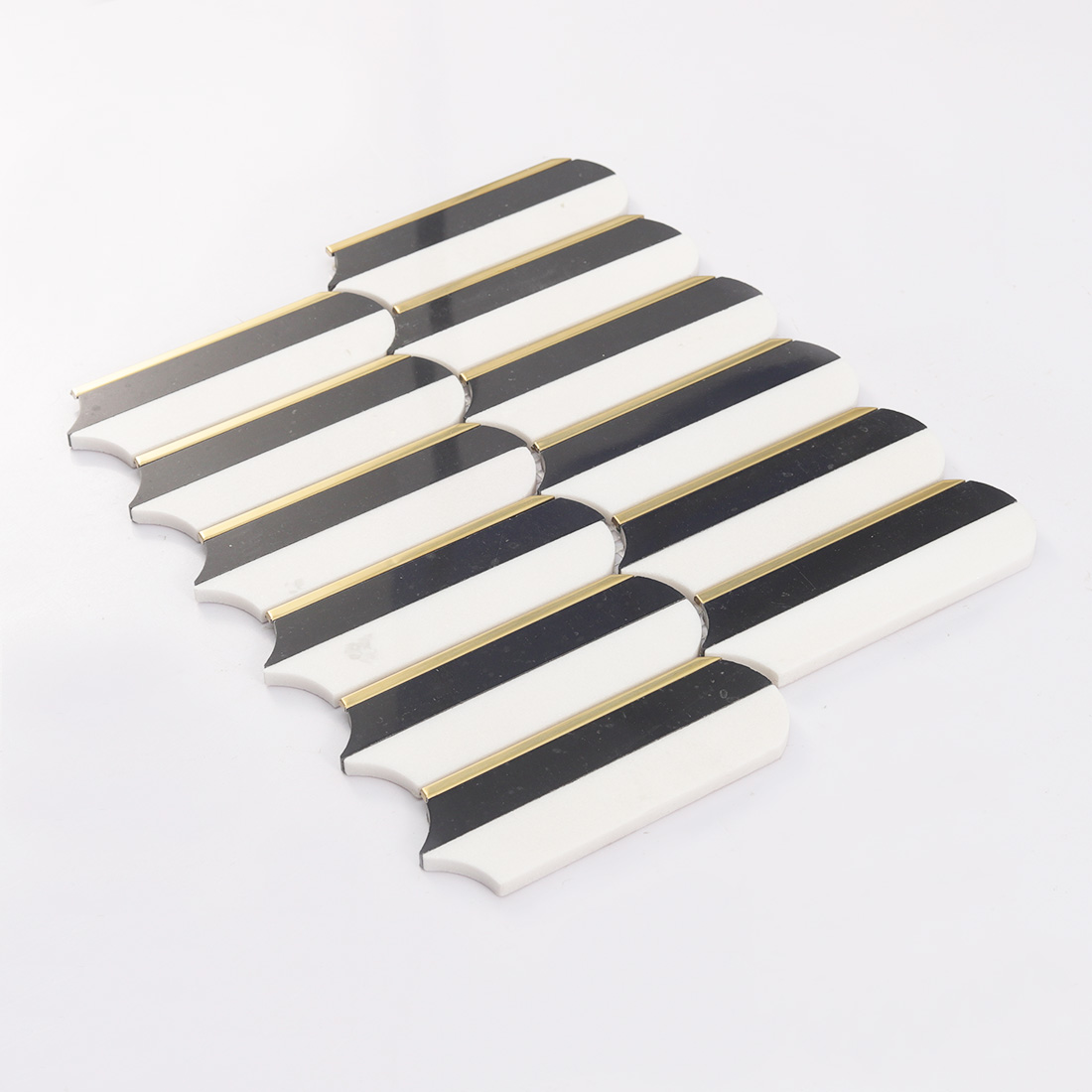 Perspective view of elongated black white mosaic tile sheet with gold trim