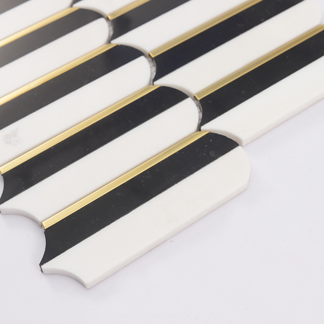 Angled view of black white mosaic tiles with gold trim accents