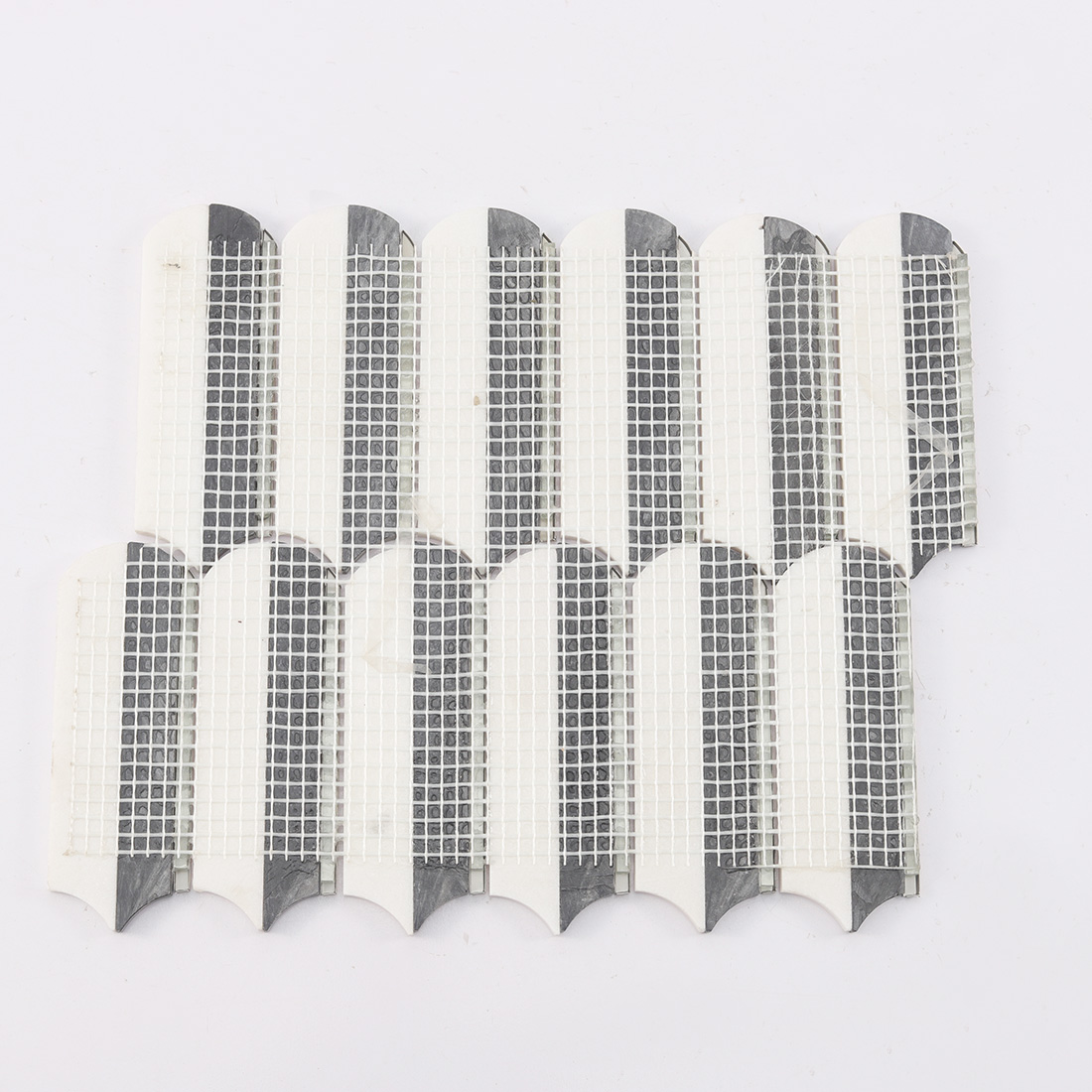 Back view of black white elongated mosaic tile sheet with mesh backing