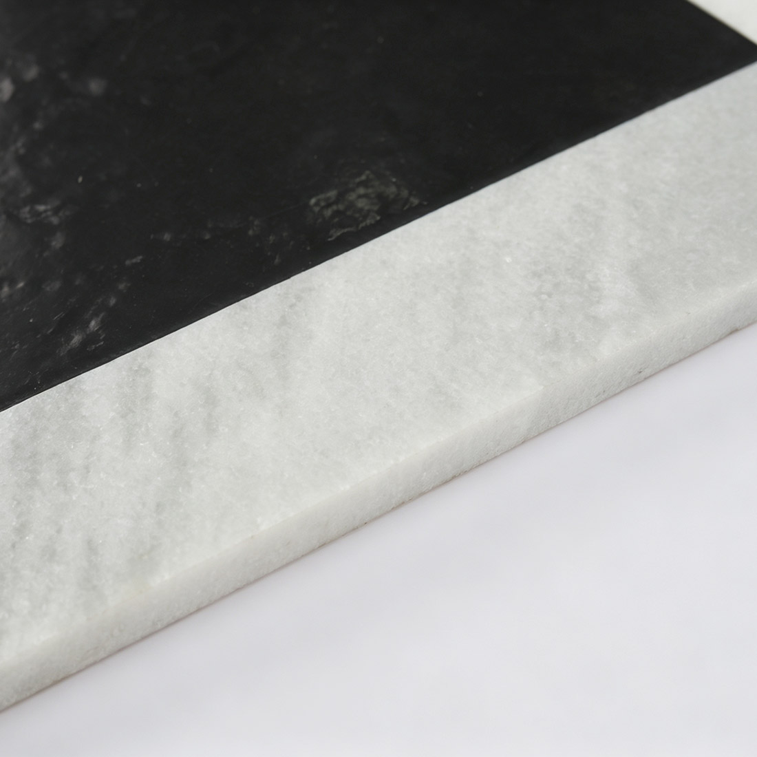 Close-up showing black and white marble floor tile edge thickness