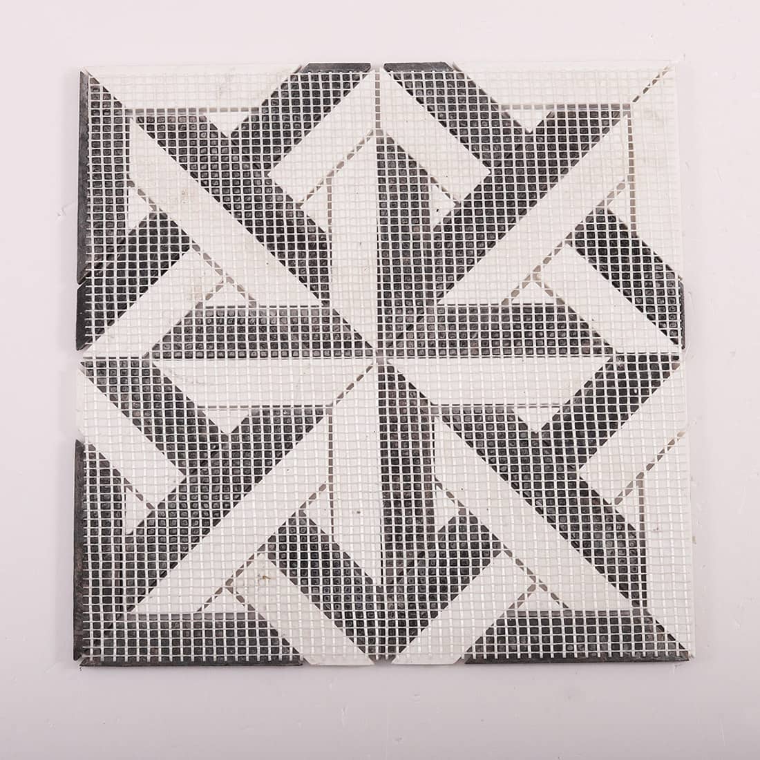 Back view of black and white geometric mosaic sheet with fiberglass mesh backing