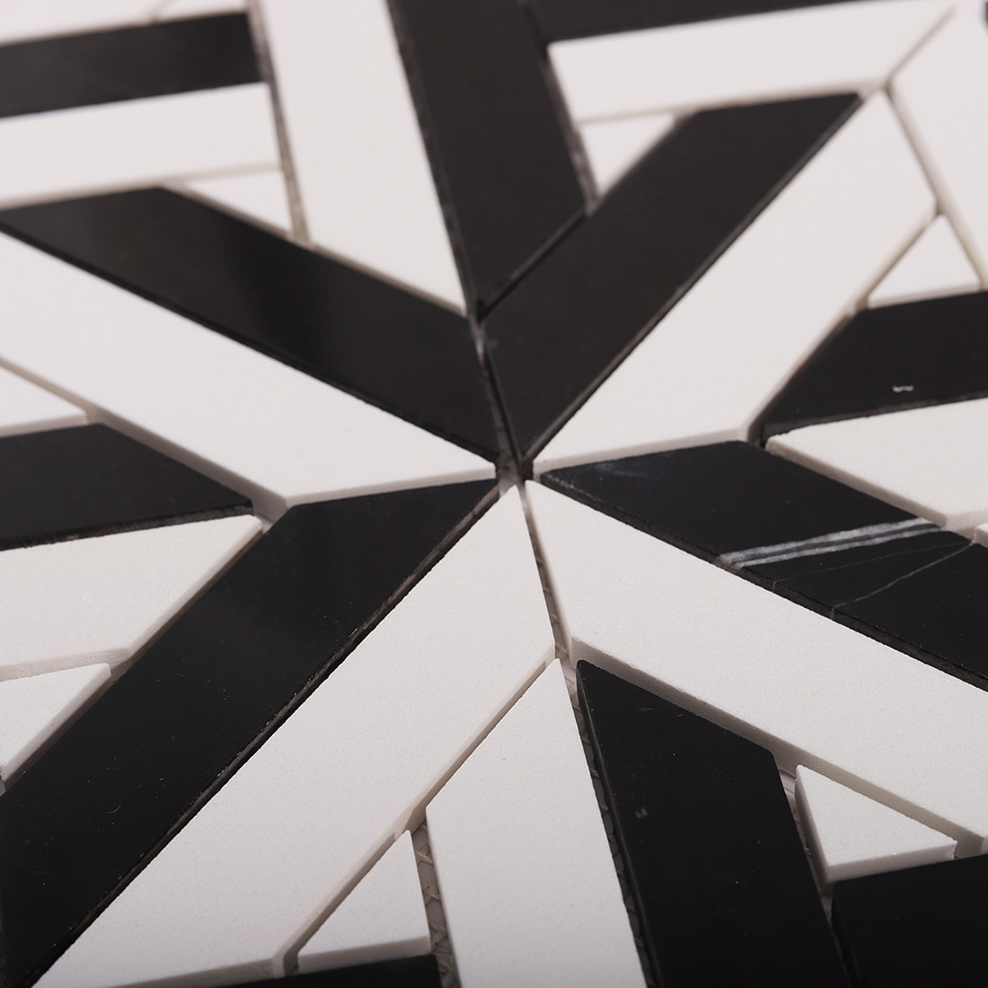 Close up of black and white mosaic star pattern with clean grout lines