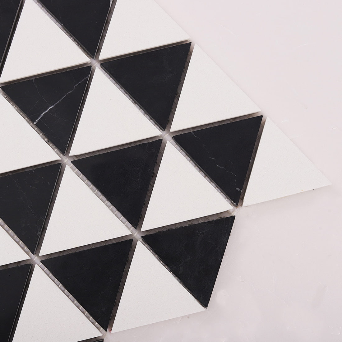 Corner close up of black and white triangle mosaic with clean joints