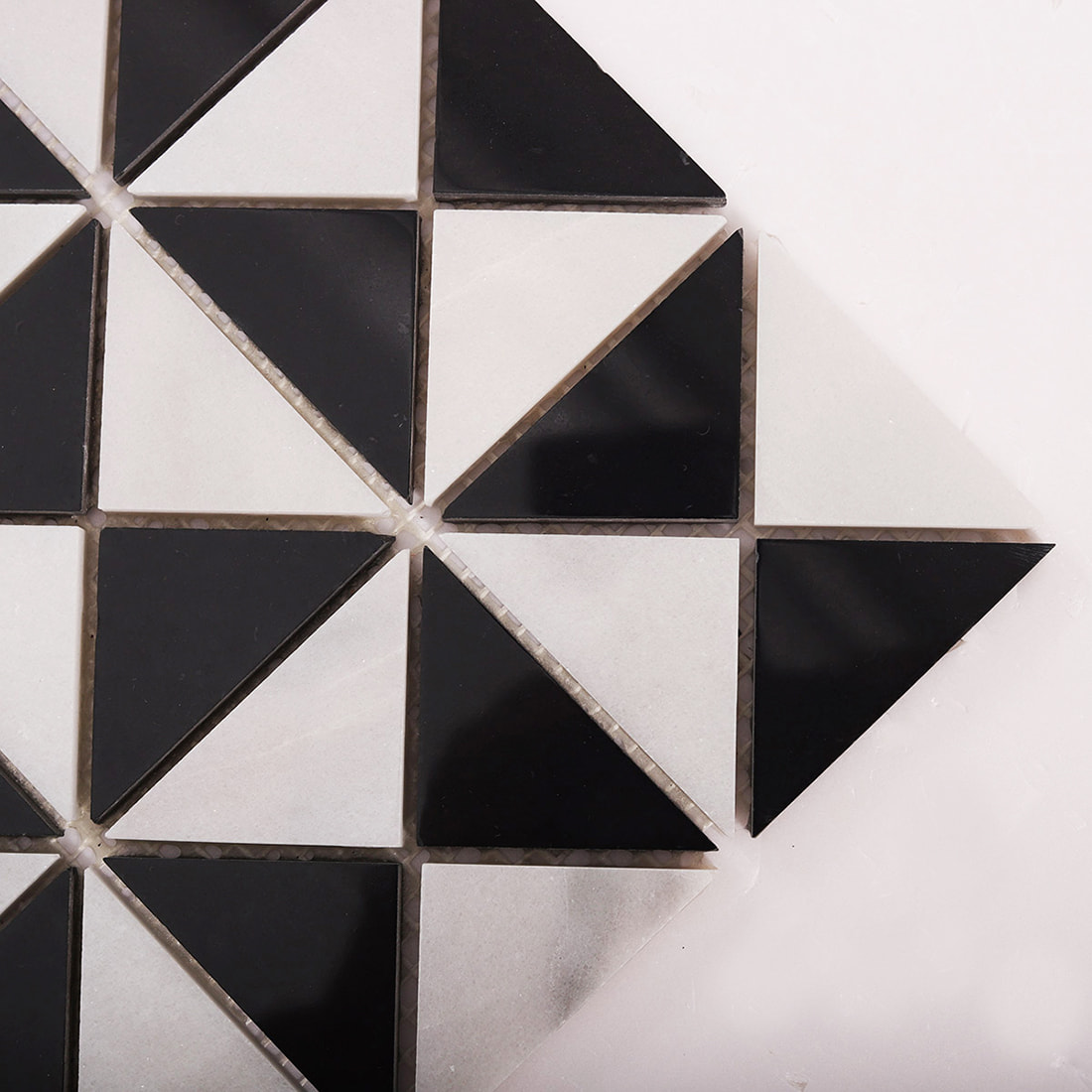 Corner close up of black and white triangle mosaic showing sharp cuts and joints