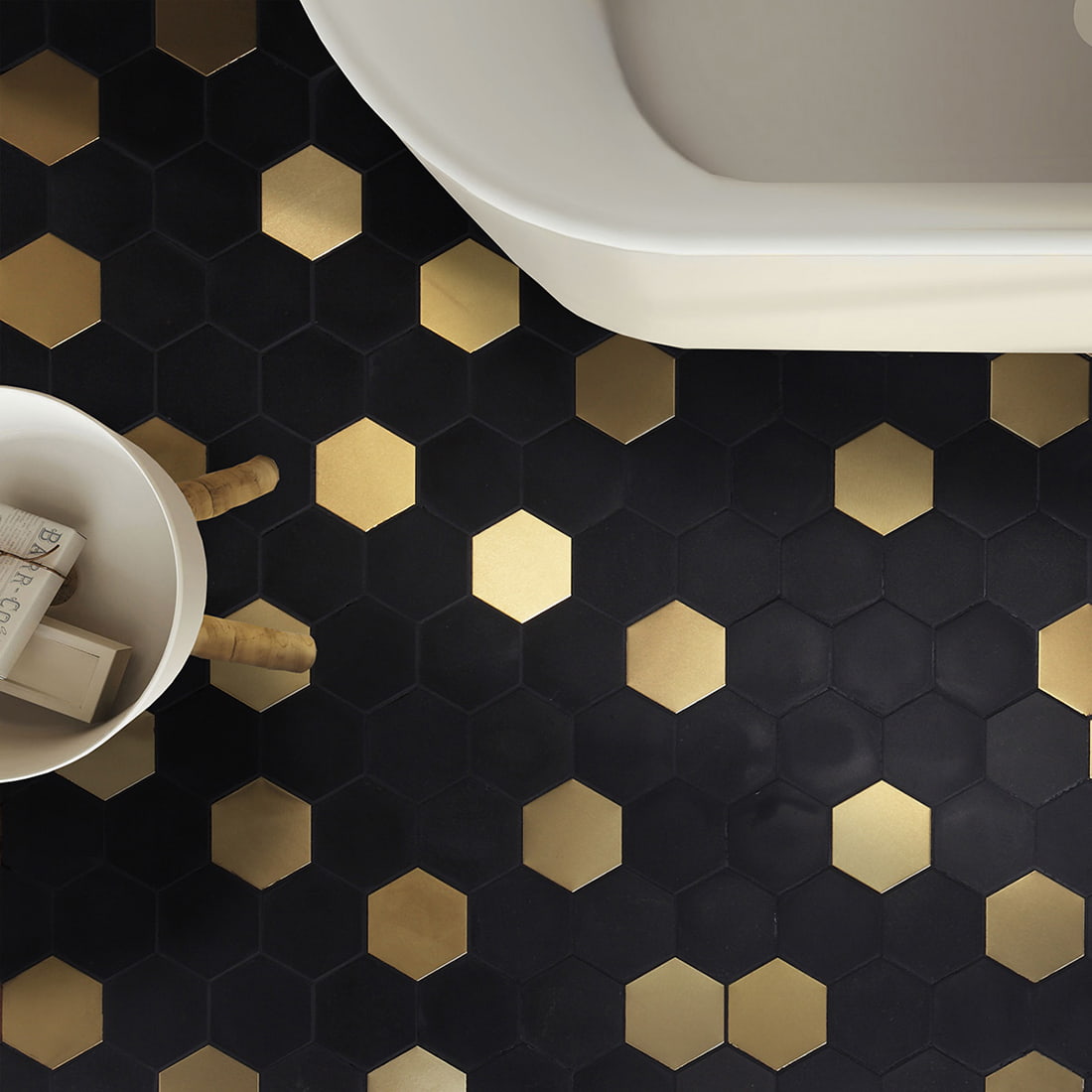 Modern bathroom floor featuring black and gold hexagonal mosaic tile patterns.