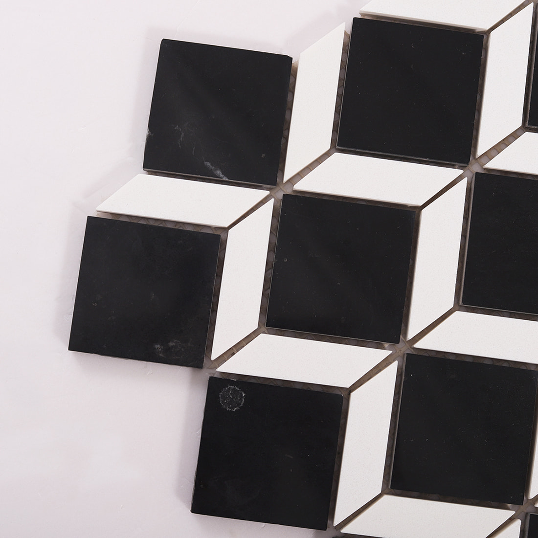 Close-up of black and white marble mosaic tile corner with beveled geometric pieces