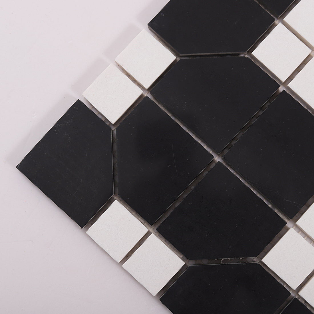 Corner detail of black and white marble mosaic tiles with beveled edges