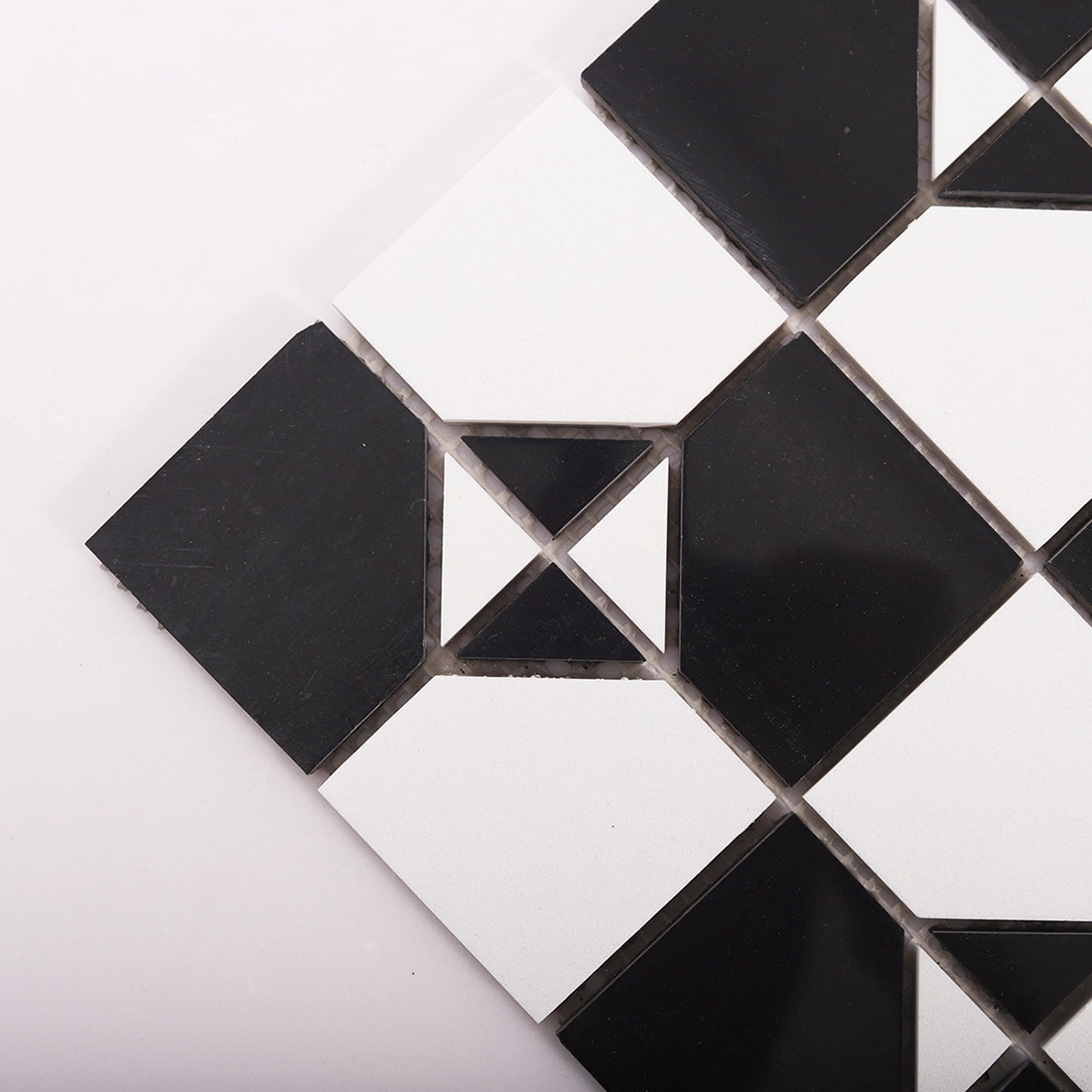 Angled close up of black and white marble mosaic showing triangle corner detail