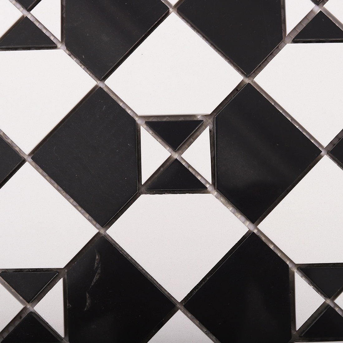 Close up of black and white square marble mosaic pattern with geometric accents