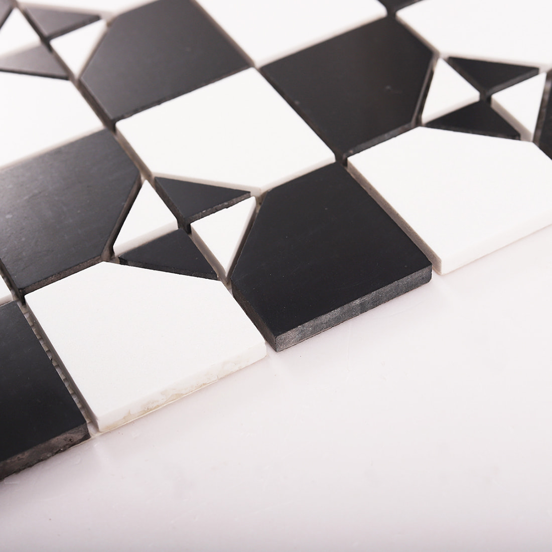 Close up of tile edge thickness on black and white square marble mosaic sheet