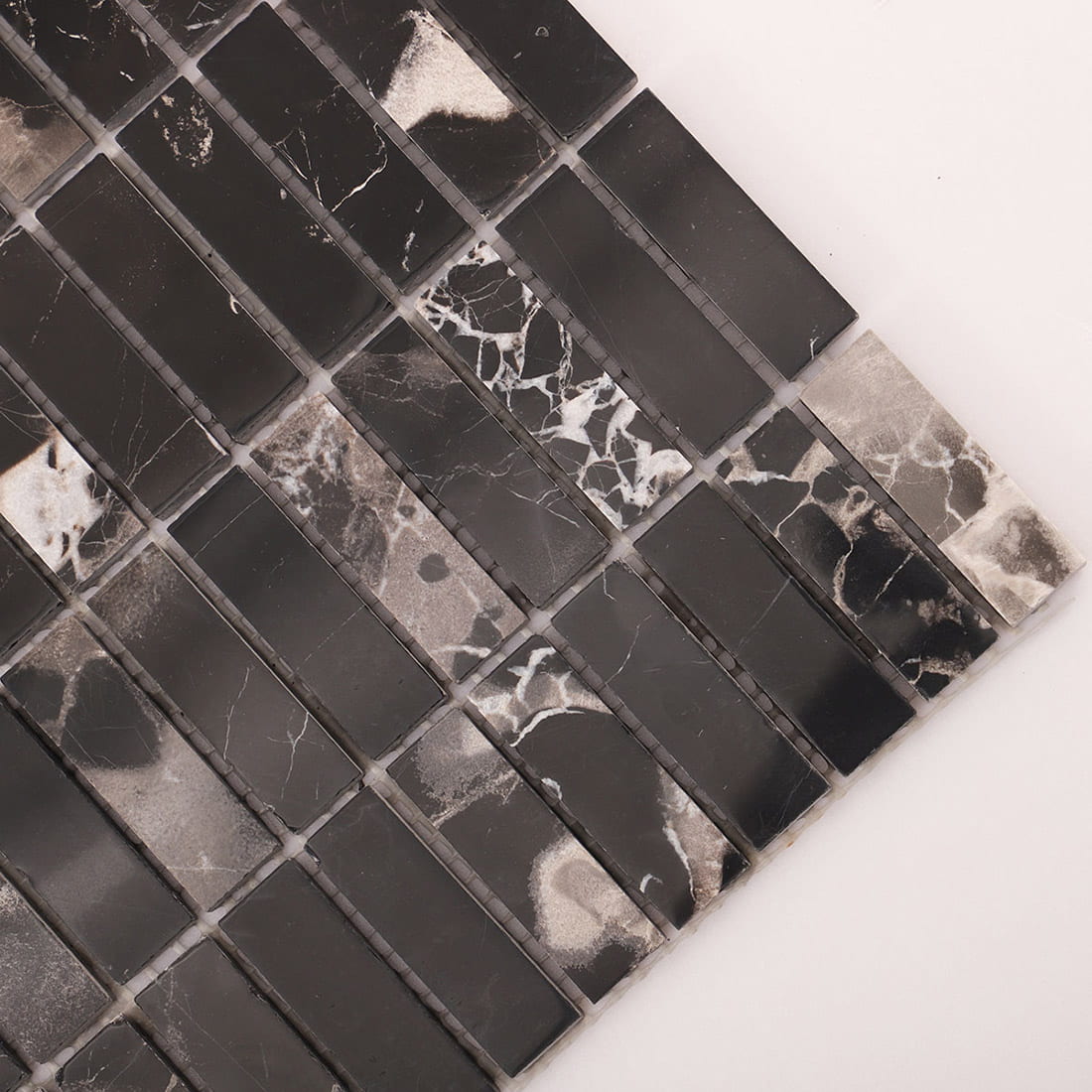 Diagonal corner close-up of black marble strip mosaic with natural veining