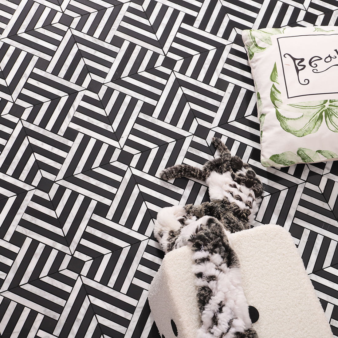 Wide lifestyle shot of geometric mosaic floor with decorative pillow