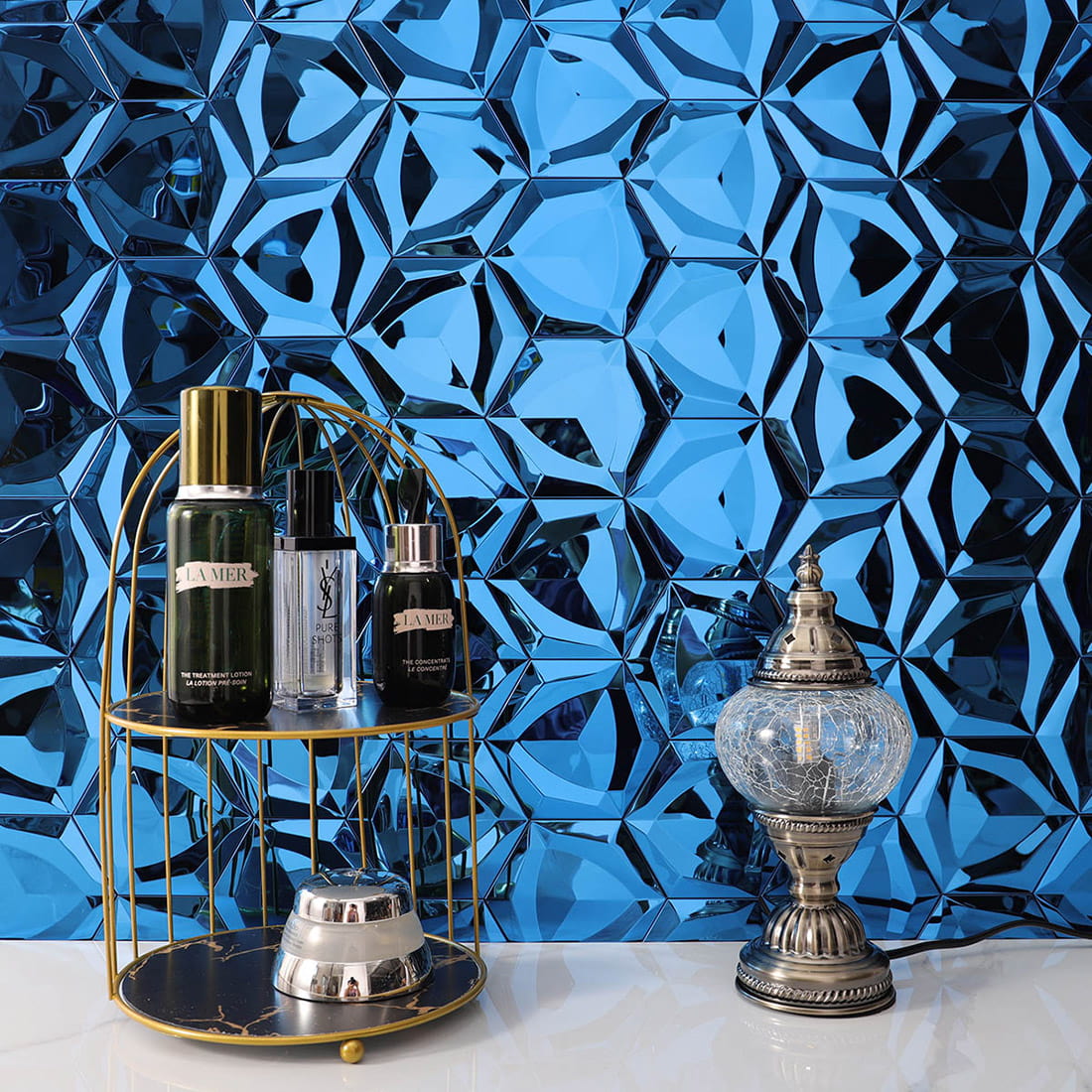 Luxury bathroom wall featuring blue 3D hexagon mosaic tiles with decorative items.