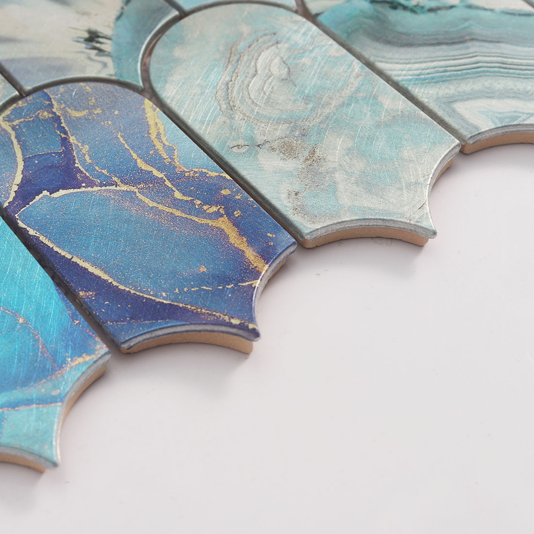Edge detail of blue rounded arch aluminum mosaic tile with layered thickness
