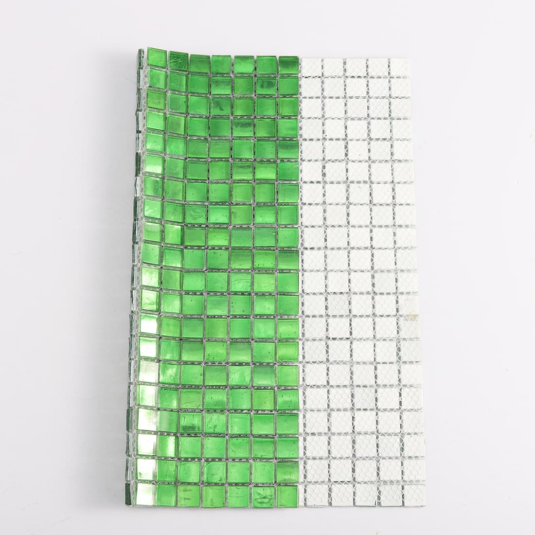 Side view of bright green glass mosaic tile sheet showing front tiles and mesh backing