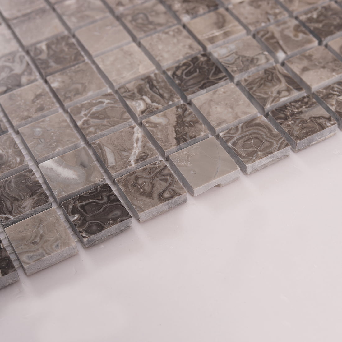 Angled view of brown marble square mosaic tiles showing thickness and joints