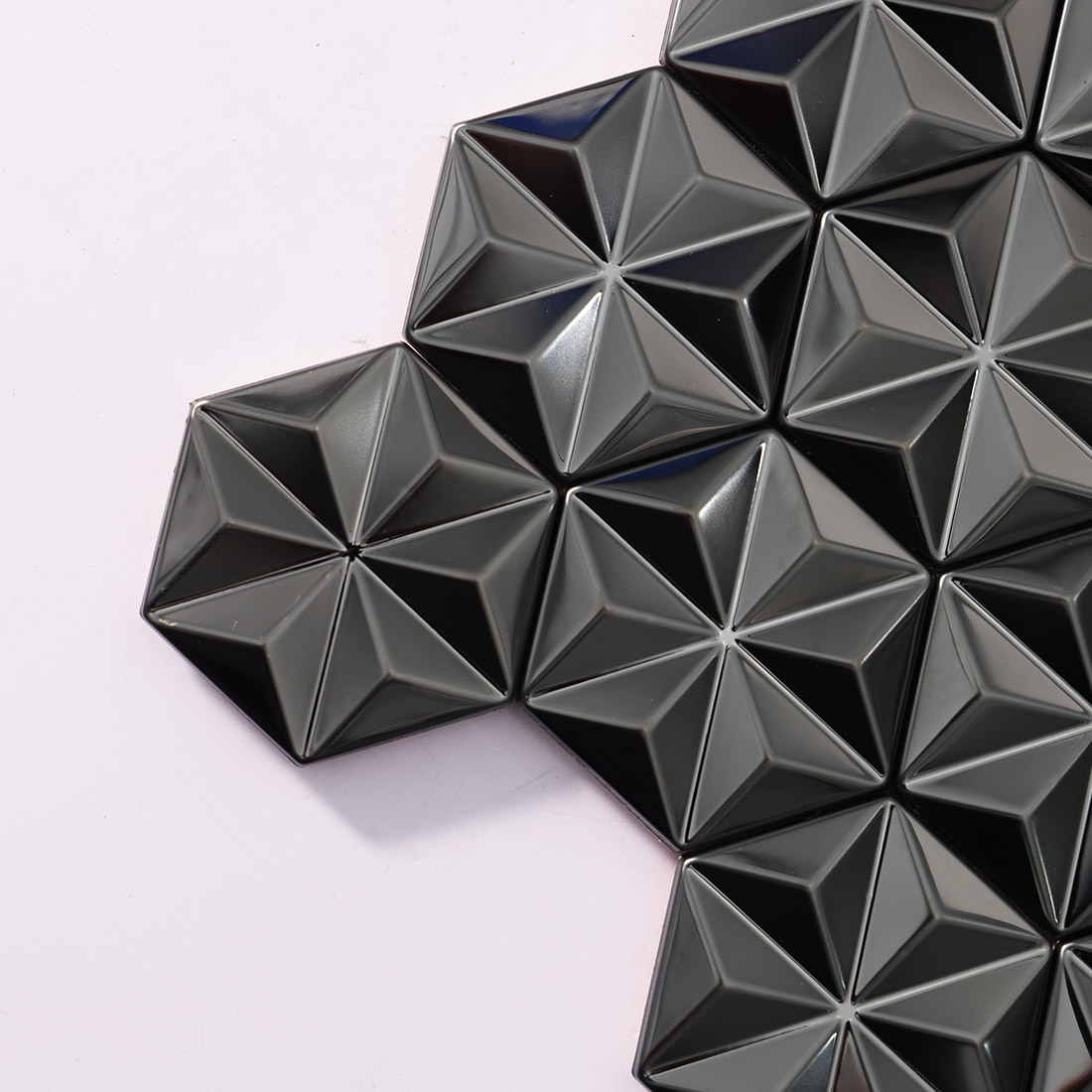 Corner detail of brushed black geometric metal mosaic tiles