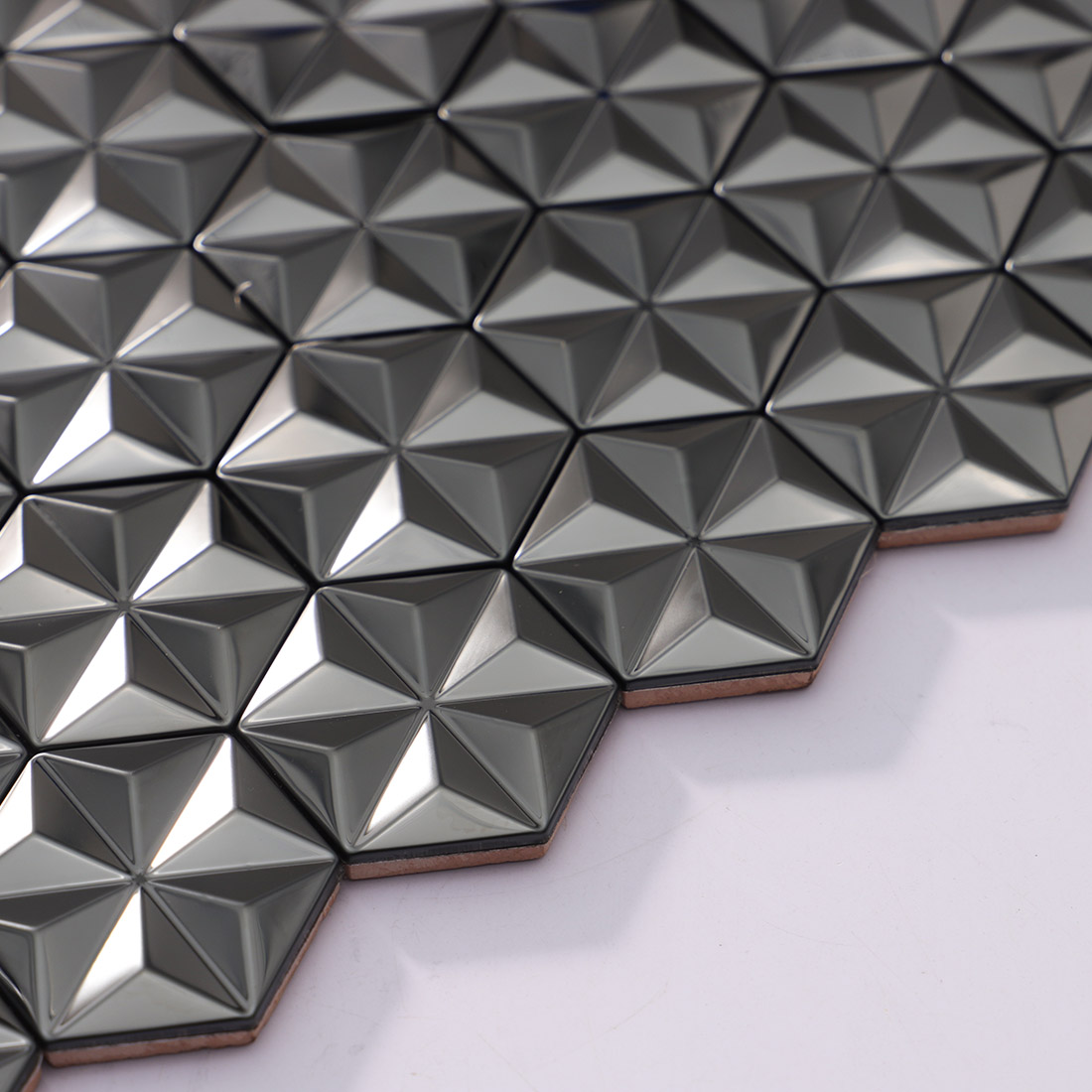 Angled view of brushed black geometric metal mosaic tile sheet edge