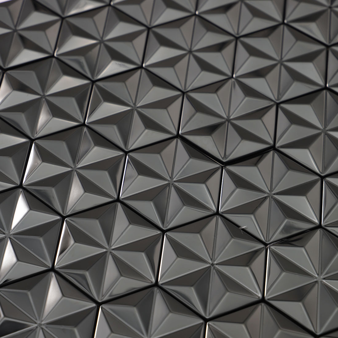 Close-up texture of brushed black 3D geometric metal mosaic tiles