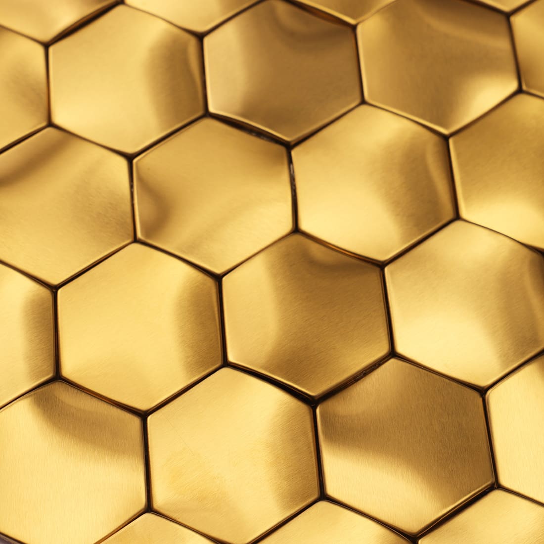 A close-up view capturing the brushed texture and 3D sheen of gold hexagon tiles.