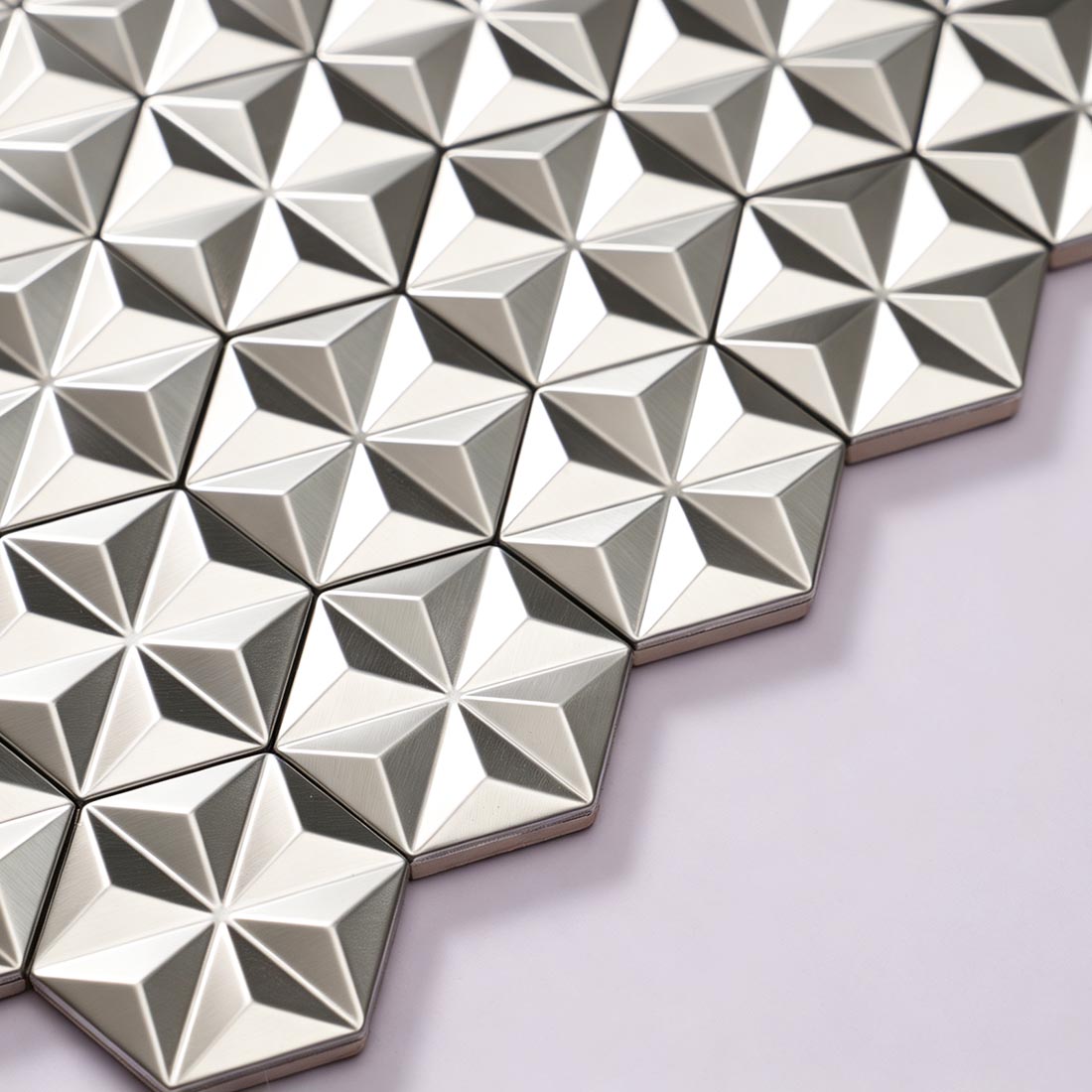 Angled view of brushed silver hexagon metal mosaic tile sheet edge