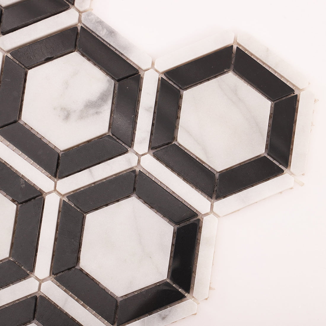 Close up of Carrara White and Nero Marquina hexagon mosaic corner joints