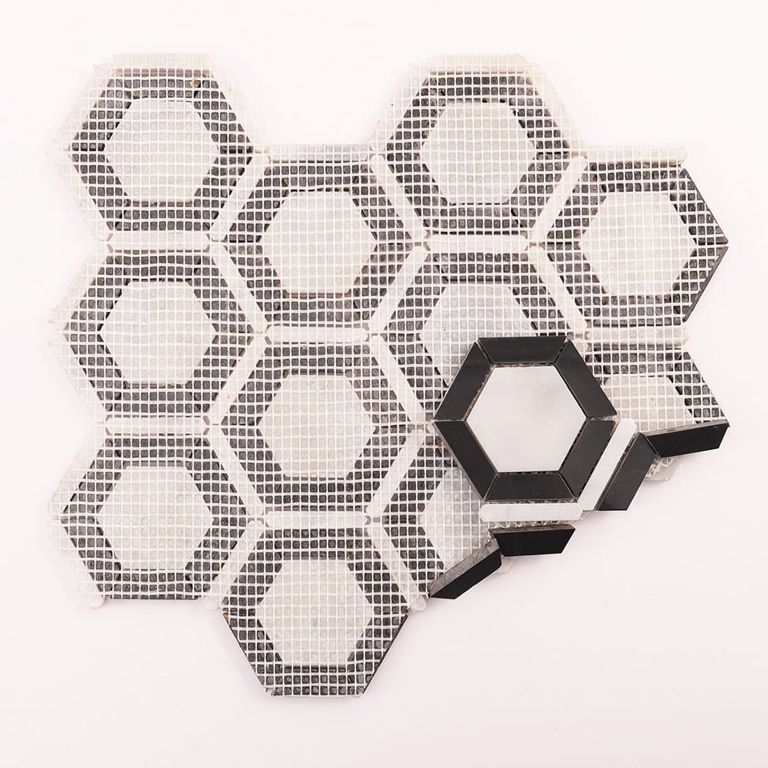 Back view of Carrara White and Nero Marquina hexagon mosaic tile with mesh backing
