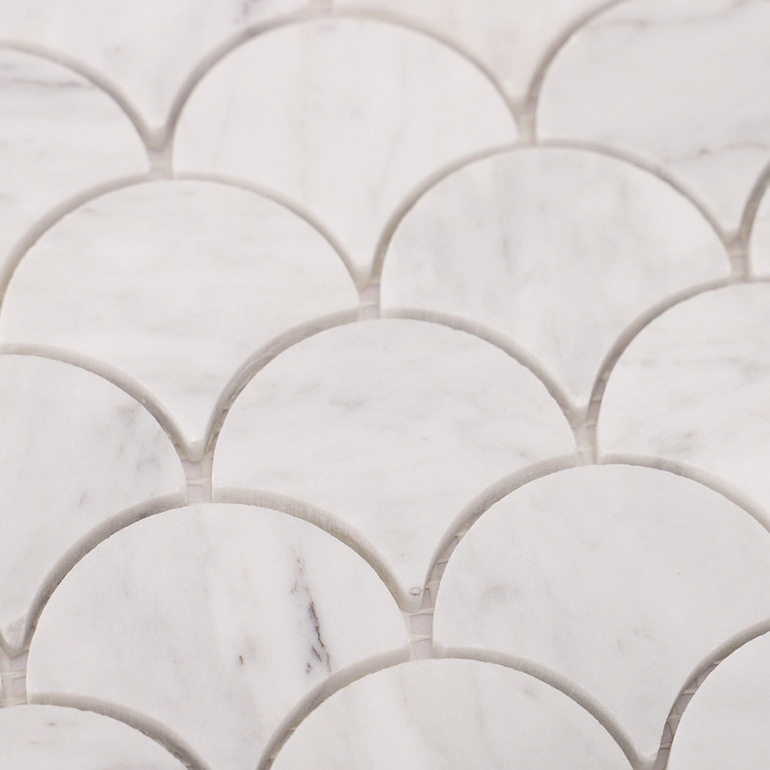 Close up of Carrara white marble fish scale pattern showing natural veining and spacing