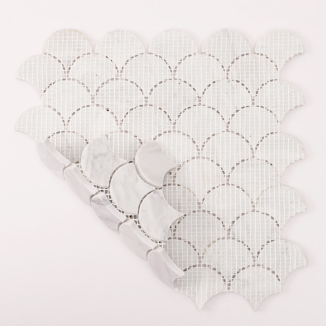 Back view of Carrara white marble fish scale mosaic sheet showing mesh backing structure